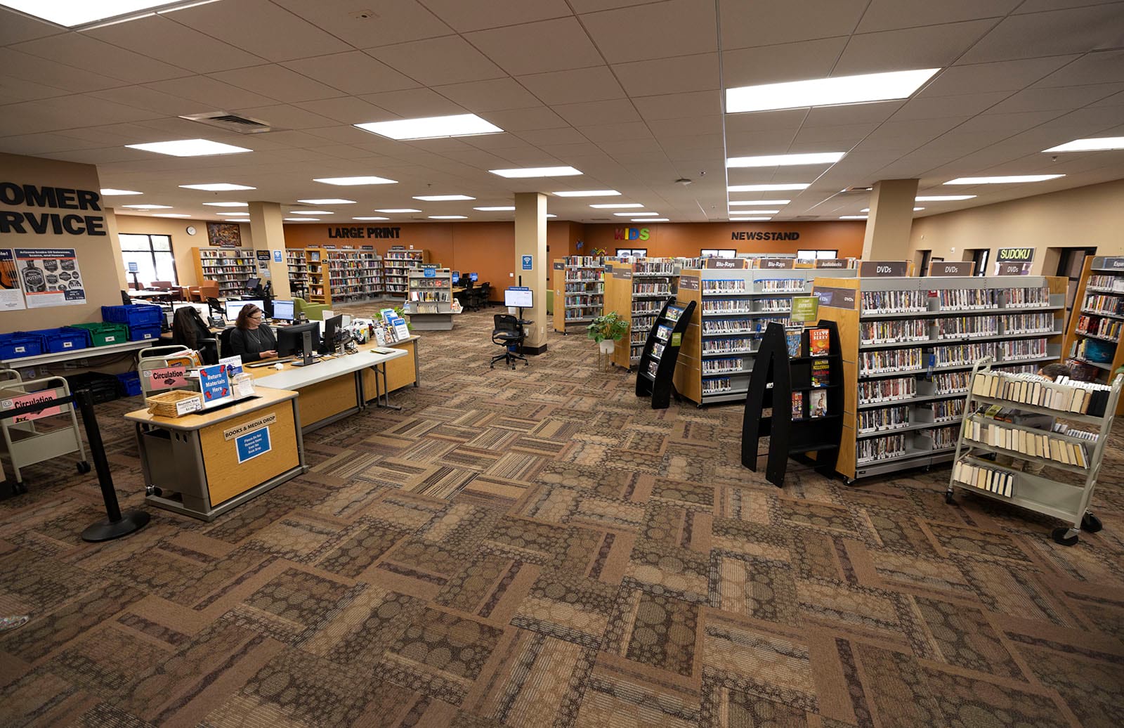 Photo from the entrance of the library of the service desk and shelves